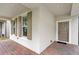 Inviting front porch with decorative brick flooring, and paneled front door, and windows with brown shutters at 16013 Tollington Aly, Winter Garden, FL 34787