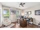 Comfortable home office with a large desk, chair, bookshelf, and natural light from two windows at 16013 Tollington Aly, Winter Garden, FL 34787