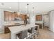 Open kitchen featuring a large island with seating, modern appliances, and wood-look tile flooring at 16013 Tollington Aly, Winter Garden, FL 34787
