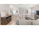 Bright living room with a large sectional, wood-look flooring, and a staircase with modern decor at 16013 Tollington Aly, Winter Garden, FL 34787
