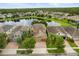 Panoramic aerial view features well-maintained homes with manicured lawns, mature trees, and water views at 1613 Water Elm Ct, Orlando, FL 32825