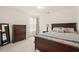 Cozy bedroom with a wooden bed, large chest, side table lamp, mirror, and plenty of natural light at 1613 Water Elm Ct, Orlando, FL 32825