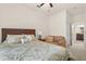Bedroom with a wooden bed frame, soft patterned linens, and a cozy reading area with a comfy sofa at 1613 Water Elm Ct, Orlando, FL 32825
