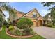 Elegant home exterior with a stone-accented facade, manicured garden, and a three-car garage at 1613 Water Elm Ct, Orlando, FL 32825