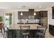 Open kitchen featuring a large island, dark cabinets, and stainless steel appliances at 1613 Water Elm Ct, Orlando, FL 32825