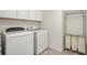 Clean laundry room featuring modern white appliances and functional storage for added convenience at 1613 Water Elm Ct, Orlando, FL 32825