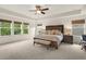 Spacious primary bedroom featuring a tray ceiling, ceiling fan, large windows, and a seating bench at 1613 Water Elm Ct, Orlando, FL 32825