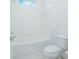 Bright and minimalist bathroom with a tub, toilet, and natural light from high window at 171 Seville Dr, Davenport, FL 33837