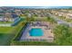 Community pool with lounge chairs, tables, and neatly trimmed hedges, ideal for relaxation and enjoyment at 171 Seville Dr, Davenport, FL 33837