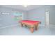 Game room with a red pool table, neutral paint, and window for natural light at 171 Seville Dr, Davenport, FL 33837