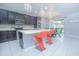 Modern kitchen with dark cabinets, an island, and a connected dining area at 171 Seville Dr, Davenport, FL 33837