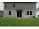 View of the backyard and siding of home featuring sliding glass doors and a well-manicured lawn at 17305 Cagan Crossings Blvd, Clermont, FL 34714