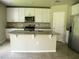 Modern kitchen featuring an island, granite countertops, stainless steel appliances, and white cabinetry at 17305 Cagan Crossings Blvd, Clermont, FL 34714