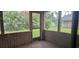 Screened porch with wood frame and walls overlooking the backyard with tropical plants at 2008 Juniper Dr, Edgewater, FL 32141