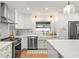 Modern kitchen featuring stainless steel appliances, white cabinetry, and quartz countertops at 207 Ramsbury Ct, Longwood, FL 32779