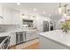 Bright kitchen features white cabinets, stainless steel appliances, farmhouse sink, and quartz countertops at 207 Ramsbury Ct, Longwood, FL 32779