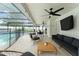 Screened-in patio with comfortable seating, ceiling fans, and a view of the pool at 207 Ramsbury Ct, Longwood, FL 32779