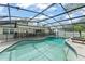 A gorgeous, enclosed pool area featuring a kidney-shaped pool, tiled border, and lounge chairs at 207 Ramsbury Ct, Longwood, FL 32779