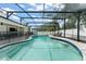 A gorgeous, enclosed pool area featuring a kidney-shaped pool, tiled border, and lounge chairs at 207 Ramsbury Ct, Longwood, FL 32779