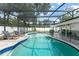 A gorgeous, enclosed pool area featuring a kidney-shaped pool, tiled border, and lounge chairs at 207 Ramsbury Ct, Longwood, FL 32779