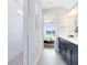 Bright bathroom leading to the bedroom with a sleek shower and dark vanity at 2267 Mossy Vine Ave, St Cloud, FL 34771