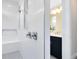 Contemporary shower with white tiles and gray mosaic floor, offering a glimpse into a stylish vanity area at 2267 Mossy Vine Ave, St Cloud, FL 34771