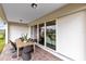 Covered patio with brick pavers and modern outdoor dining furniture, view of large glass sliding doors at 2267 Mossy Vine Ave, St Cloud, FL 34771