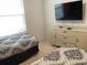 Cozy bedroom featuring two twin beds, tile floors, dresser, and mounted television at 2305 Butterfly Palm Way # 304, Kissimmee, FL 34747