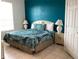 Bright bedroom with a TV, tile floor, dresser, bright blue accent wall, and bright window at 2305 Butterfly Palm Way # 304, Kissimmee, FL 34747