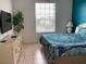 Bright bedroom with a TV, tile floor, dresser, and bright window with natural light at 2305 Butterfly Palm Way # 304, Kissimmee, FL 34747