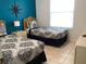 Cozy bedroom featuring two twin beds, tile floors, and a bright accent wall at 2305 Butterfly Palm Way # 304, Kissimmee, FL 34747