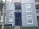 A light grey condominium building with an open walkway in a lush, green community at 2305 Butterfly Palm Way # 304, Kissimmee, FL 34747
