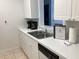 Efficient kitchen featuring white cabinets and stainless steel sink at 2305 Butterfly Palm Way # 304, Kissimmee, FL 34747
