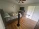 Cozy bedroom featuring hardwood floors, a comfortable bed, and natural light from sliding glass doors at 2500 21St Nw St # 58, Winter Haven, FL 33881