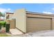 Attached one-car garage with a neutral colored door and a walkway to a private entrance at 2500 21St Nw St # 58, Winter Haven, FL 33881