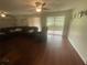 Living room with hardwood floors, ceiling fan, leather sofa and sliding glass door access to patio at 2500 21St Nw St # 58, Winter Haven, FL 33881