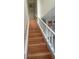 A well-lit staircase featuring light wood treads and white risers, leading to the upper level of the home at 2500 21St Nw St # 58, Winter Haven, FL 33881