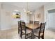 Well-lit dining room featuring a wooden table with seating for six and a view into the kitchen area at 2821 Almaton Loop # 105, Kissimmee, FL 34747
