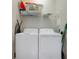 Functional laundry room area with white washer and dryer, overhead shelving, and ample storage space at 2821 Almaton Loop # 105, Kissimmee, FL 34747