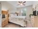 Bright bedroom with ceiling fan and floral bedding, complemented by natural light from the window at 2821 Almaton Loop # 105, Kissimmee, FL 34747