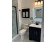Modern bathroom features black fixtures, framed mirror, toilet, and walk-in shower with marble style tile at 2864 Trenton Ln, Deltona, FL 32738