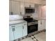 Well-equipped kitchen featuring stainless steel appliances, sleek white cabinetry, and stylish backsplash at 2864 Trenton Ln, Deltona, FL 32738