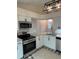 Well-lit kitchen features granite countertops, stainless steel appliances, and white cabinets at 2864 Trenton Ln, Deltona, FL 32738
