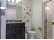 Modern bathroom with a granite vanity, toilet, and glass-enclosed shower, adorned with subtle Mickey Mouse accents at 3085 Tom Sawyer Dr, Kissimmee, FL 34746