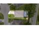 Aerial view of a home with a screened lanai, manicured lawn, mature trees and a paved driveway at 3281 Saloman Ln, Clermont, FL 34711