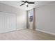 Bright bedroom with double door closet, ceiling fan, wood-look floors, and natural light at 3281 Saloman Ln, Clermont, FL 34711