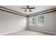 Minimalist bedroom with neutral walls, wood trim detail, light-colored wood floors, and two windows at 3281 Saloman Ln, Clermont, FL 34711