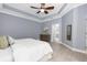 A serene bedroom features a tray ceiling, ceiling fan, and an ensuite bathroom entrance at 3281 Saloman Ln, Clermont, FL 34711