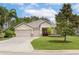 Well-maintained single-story home with a three-car garage, landscaped yard, and inviting front entrance at 3281 Saloman Ln, Clermont, FL 34711