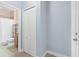 Hallway in light blue next to a partial view of the bathroom, with a white door and closet at 3281 Saloman Ln, Clermont, FL 34711